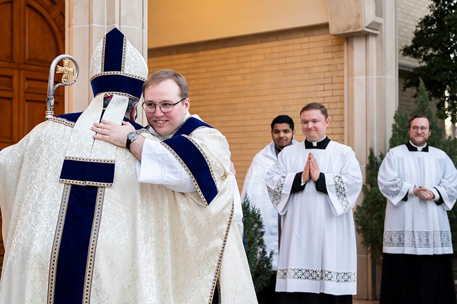 El obispo Michael Olson comparte un abrazo de celebración con el diácono Isaac McCracken después de la misa de ordenación el 19 de marzo de 2023 en la iglesia St. Maria Goretti en Arlington.